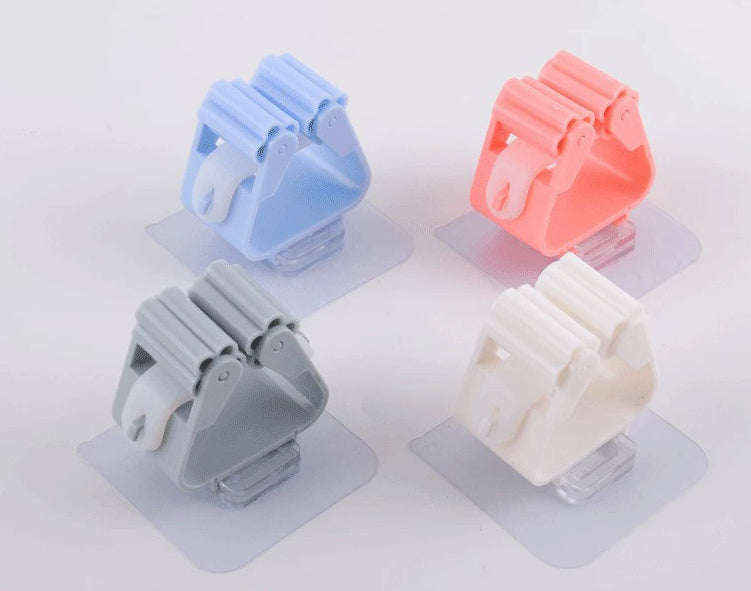 Four wall-mounted holders in blue, pink, gray and white.