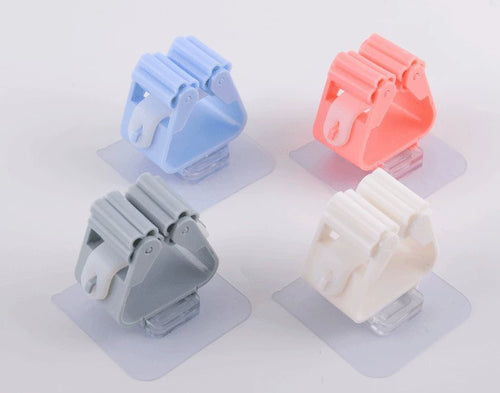 Four wall-mounted holders in blue, pink, gray and white.