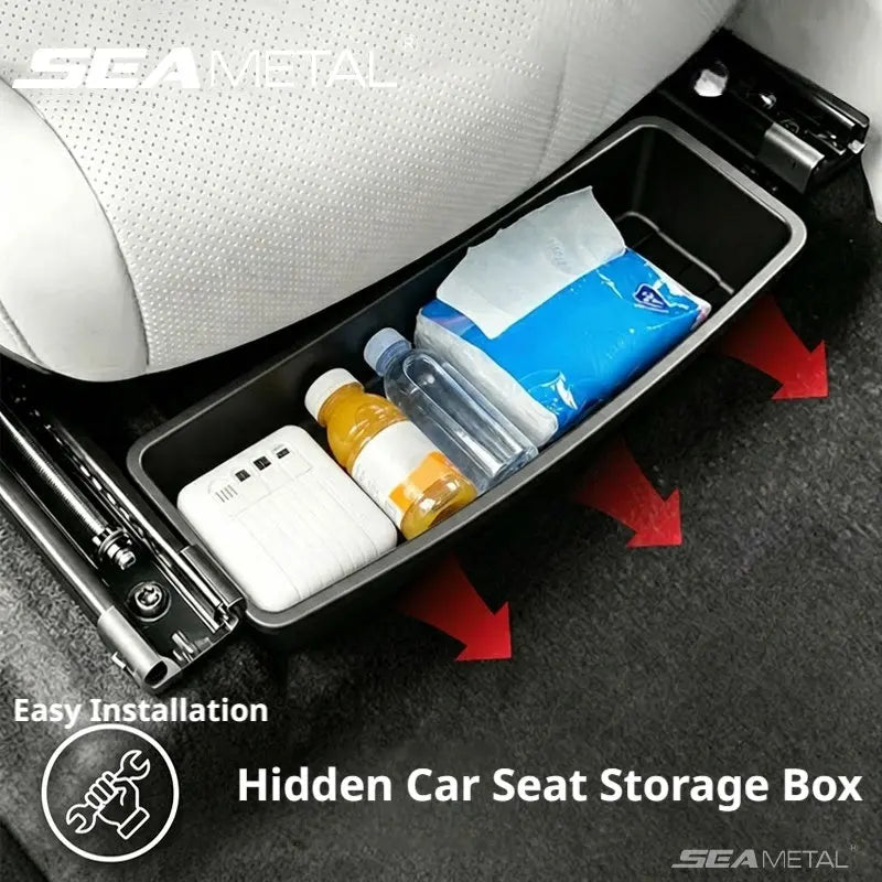 Black under-seat car storage box pulled out from beneath a white leather car seat, filled with a power bank, water bottle, juice bottle, and tissue pack, with red arrows indicating slide-out access