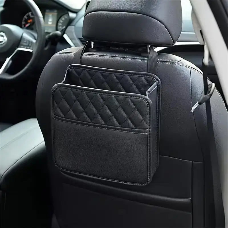 Black quilted leather car seat back organizer hanging behind a front seat in a black car interior