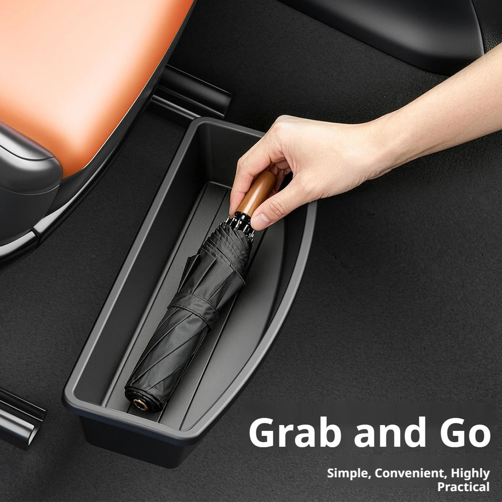 Hand pulling a folded black umbrella out of a black under-seat car storage box installed beneath an orange leather car seat, with Grab and Go text overlay