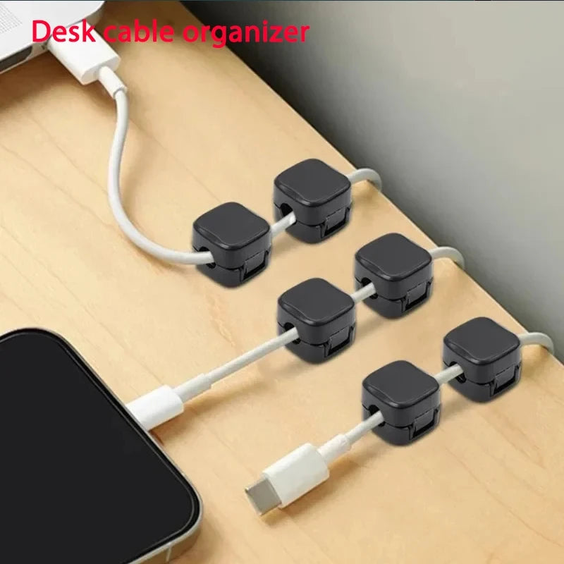 Magnetic cable organizer clips attached to a desk surface.